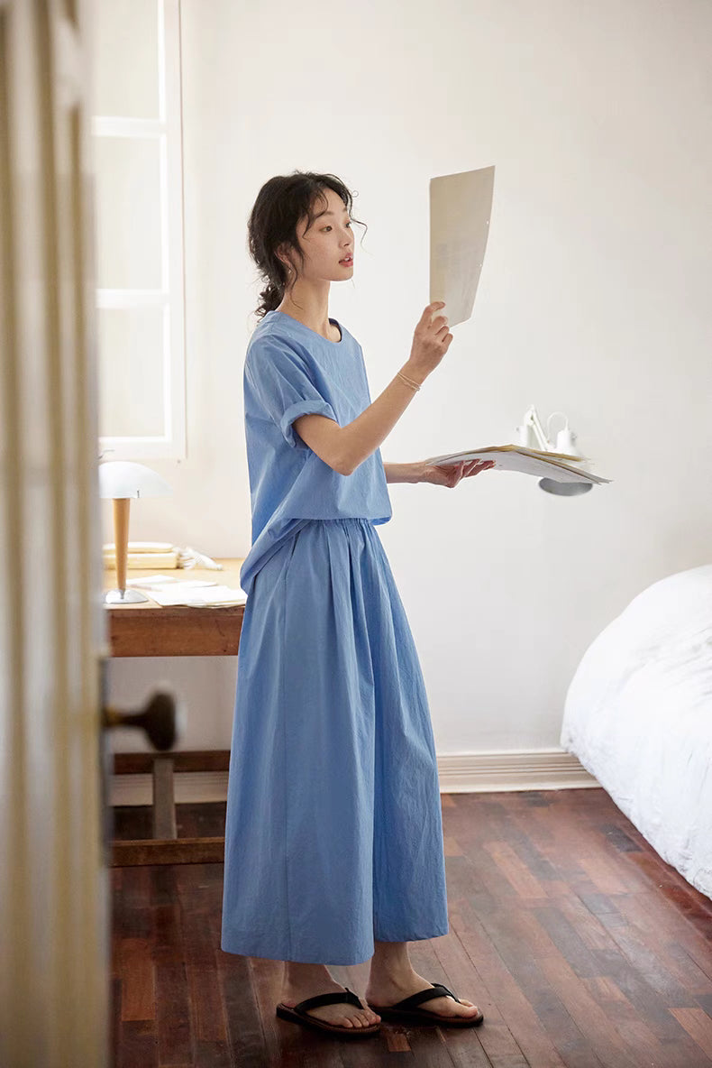 Model wearing blue Coastal Breeze Cotton Top & Skirt Set in lifestyle scene holding papers showcasing breathable fabric and relaxed everyday styling
