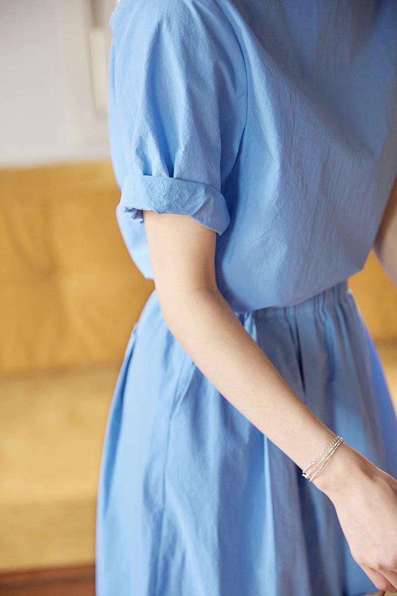 Close-up detail of Coastal Breeze Cotton Top & Skirt Set in blue highlighting rolled short sleeves and soft breathable cotton texture