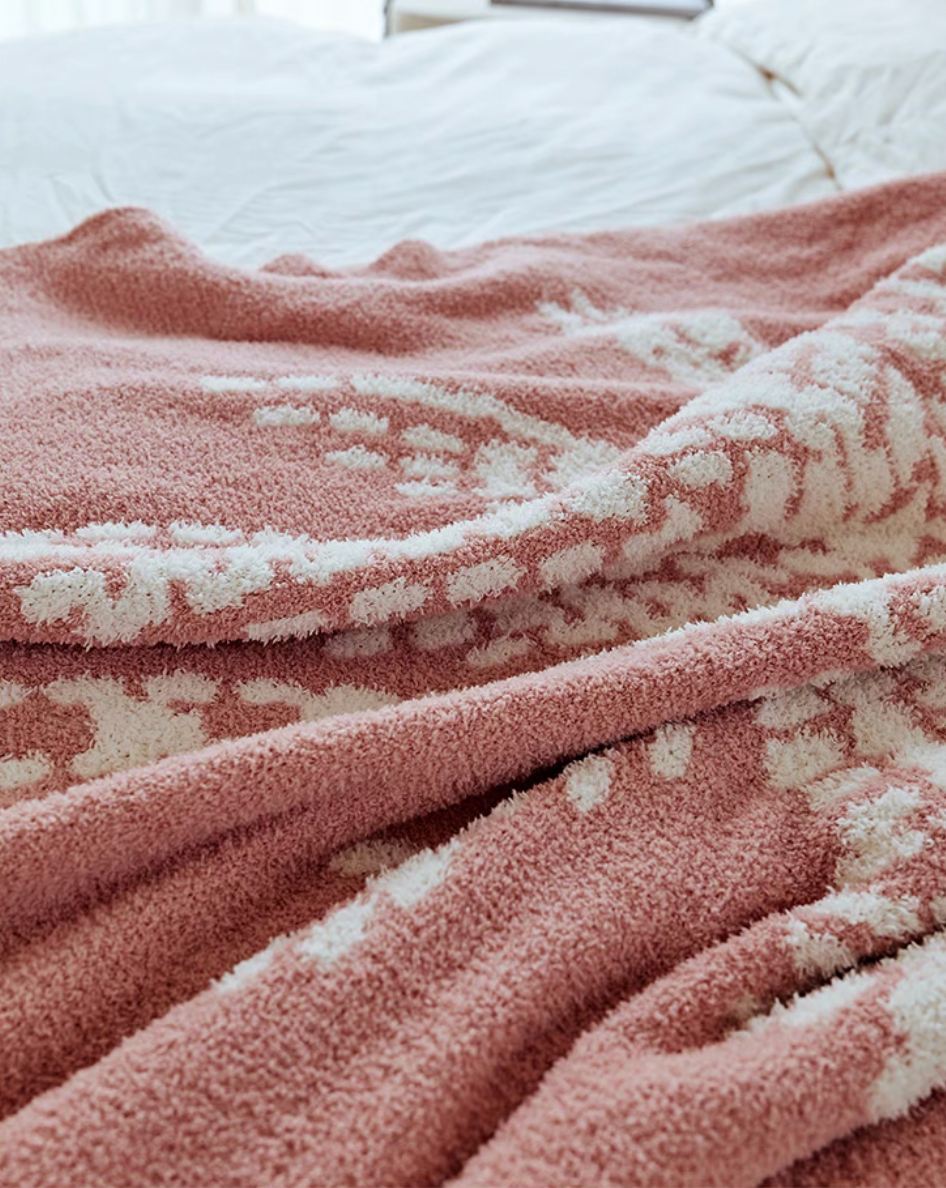 Close-up of pink coconut throw blanket highlighting plush fuzzy texture and white palm tree details