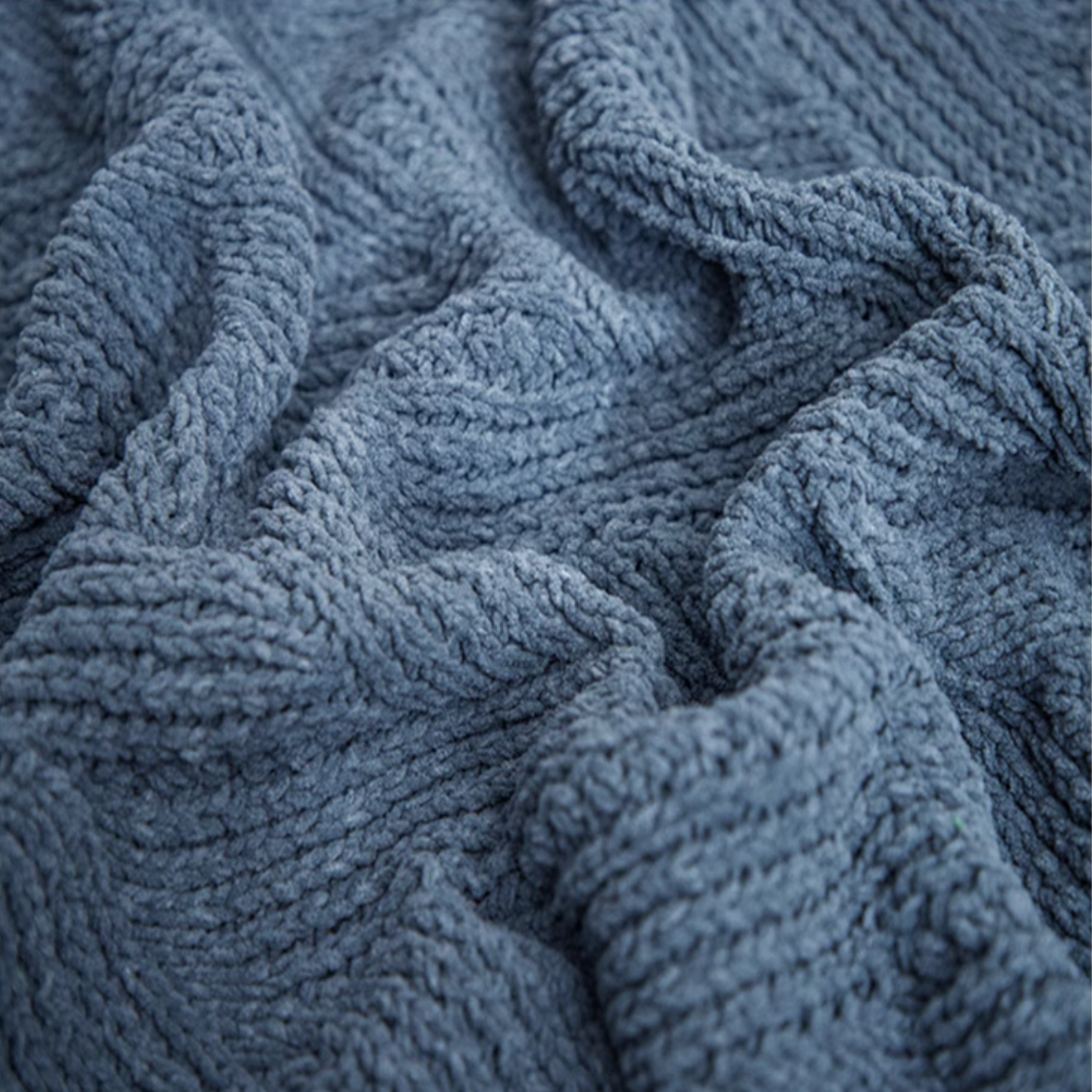 Close-up of navy blue chenille cable knit throw blanket showing dense plush fibers and cable knit pattern
