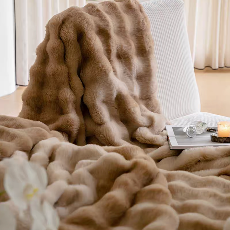 Ombre coffee plush faux fur blanket draped on chair with candle and tray, rich warm tones luxury cozy feel