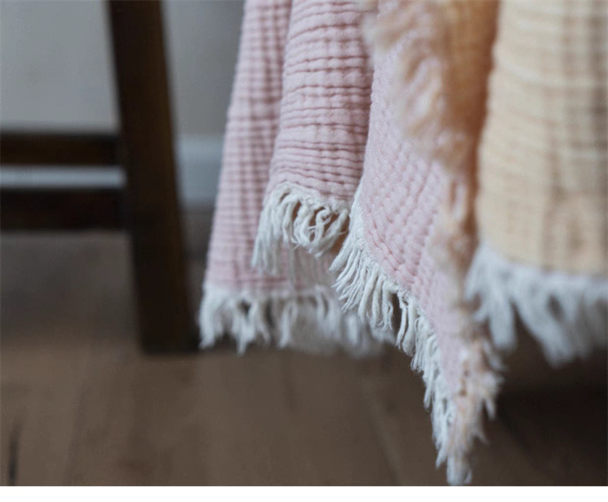 Close-up of cotton gauze throw blanket fringe edge and textured honeycomb weave detail