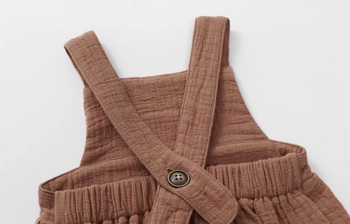 Dusty rose cotton gauze baby romper cross back strap with button detail soft breathable fabric