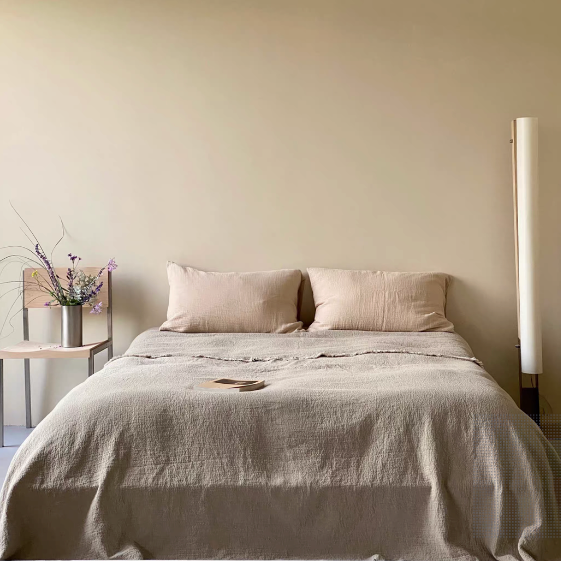 French flax linen duvet thin quilt in natural classic linen color styled on minimalist bedroom bed with raw edge texture and stonewashed linen fabric