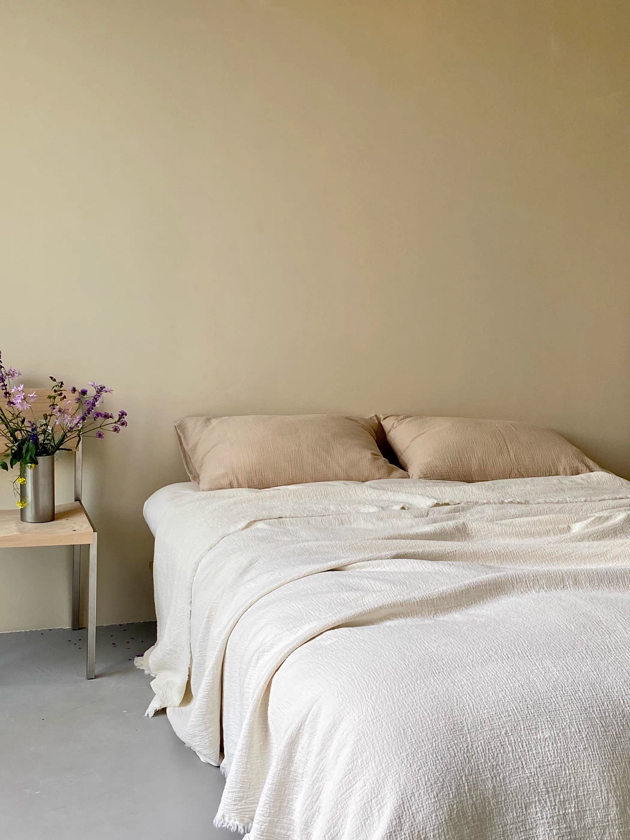 Close up of ivory white French flax linen duvet thin quilt fabric texture highlighting breathable crinkled linen weave