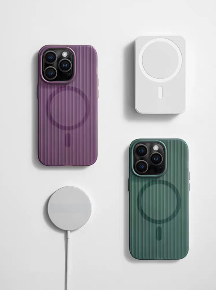 Vertical ribbed MagSafe matte phone case in aurora green and iridescent purple shown with magnetic charger accessories flat lay