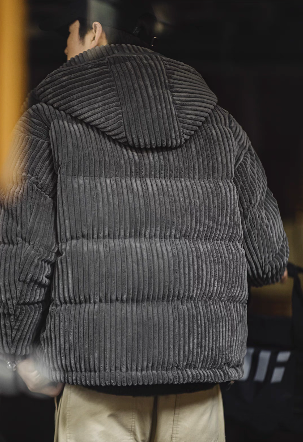 Back view of Dark Gray corduroy down jacket with removable hood highlighting padded structure and stitching