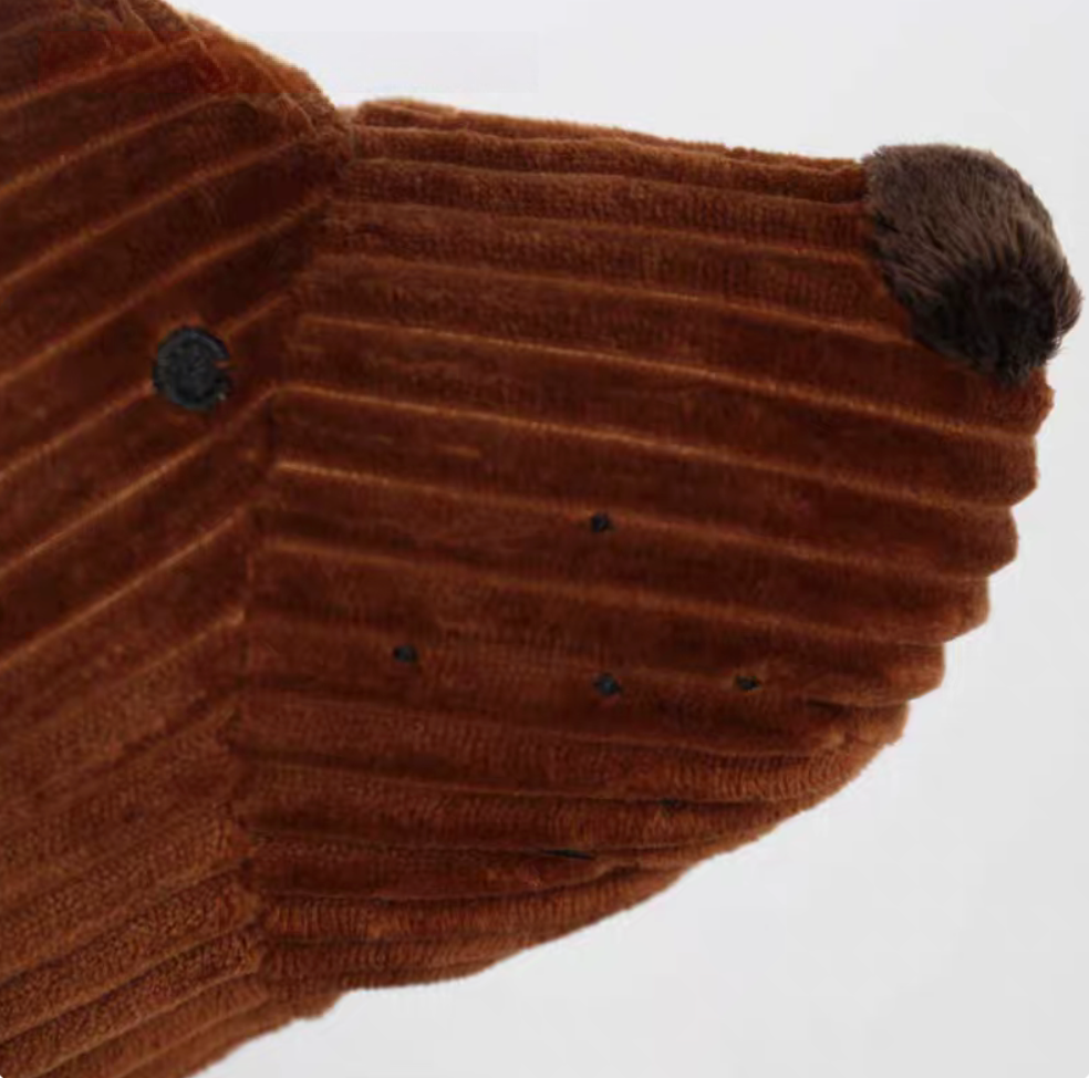 Close-up of brown dachshund pillow face showing soft corduroy texture and stitched details