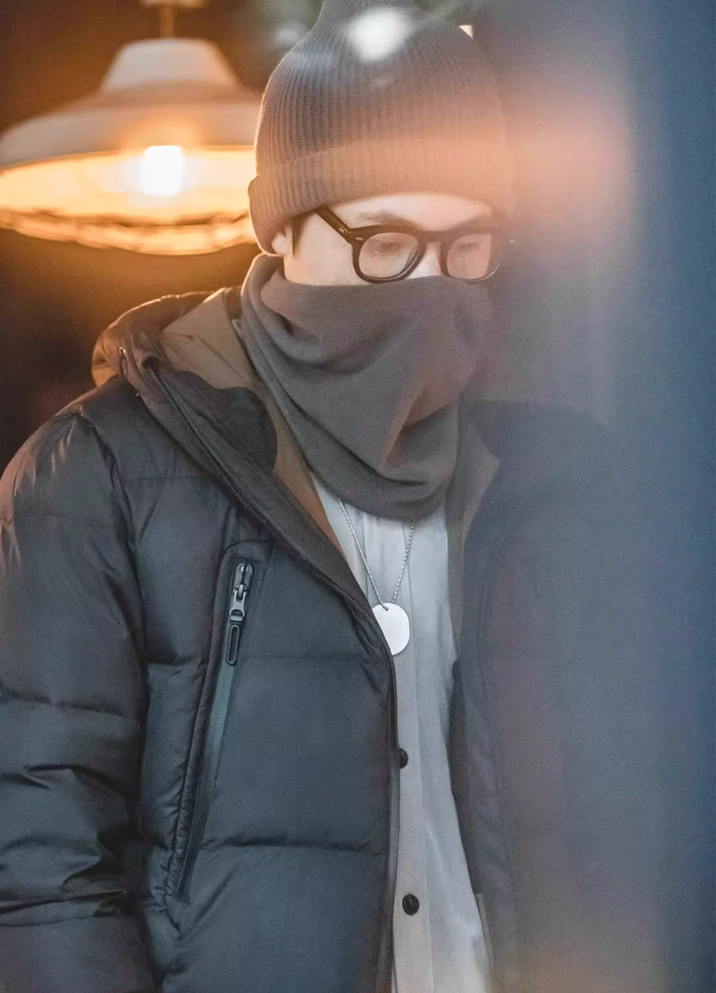 Cozy Magic Neck-Warmer in gray worn covering lower face and neck, styled with glasses and jacket for cold weather protection
