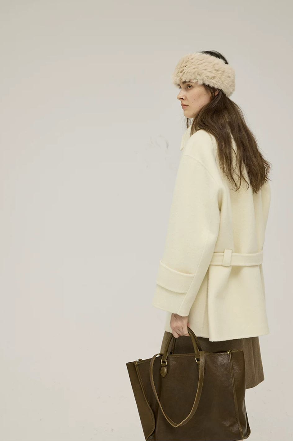 Side-back view of a Cream short wool coat showing the belt loop and wide cuff