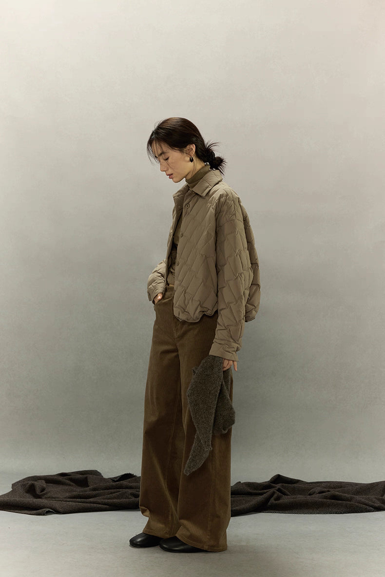 Full-body side view of khaki brown cropped quilted goose down shirt jacket styled with brown wide-leg corduroy pants.