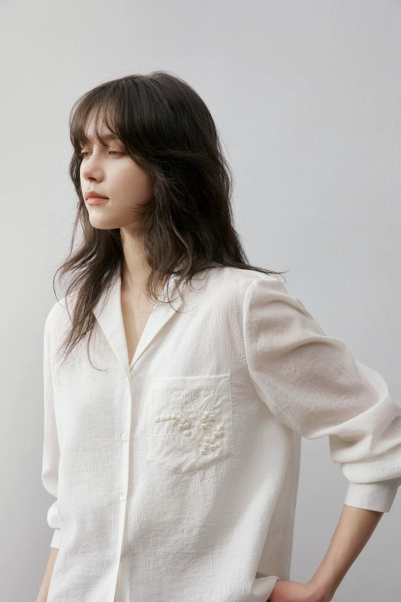 Close-up of ivory Cuban collar shirt collar and embroidery detail