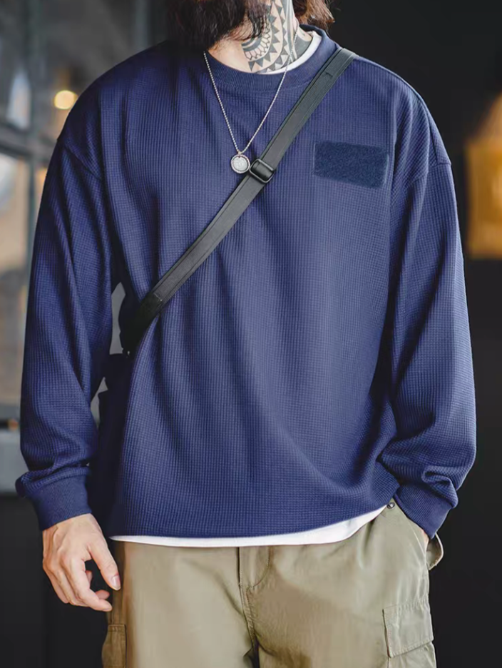 Man wearing navy blue custom Velcro long sleeve waffle tee with crossbody strap showing chest velcro patch detail