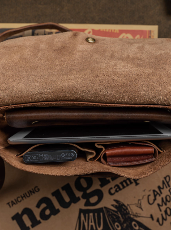 Inside view of vintage Italian leather bag showing compartments with power bank and wallet
