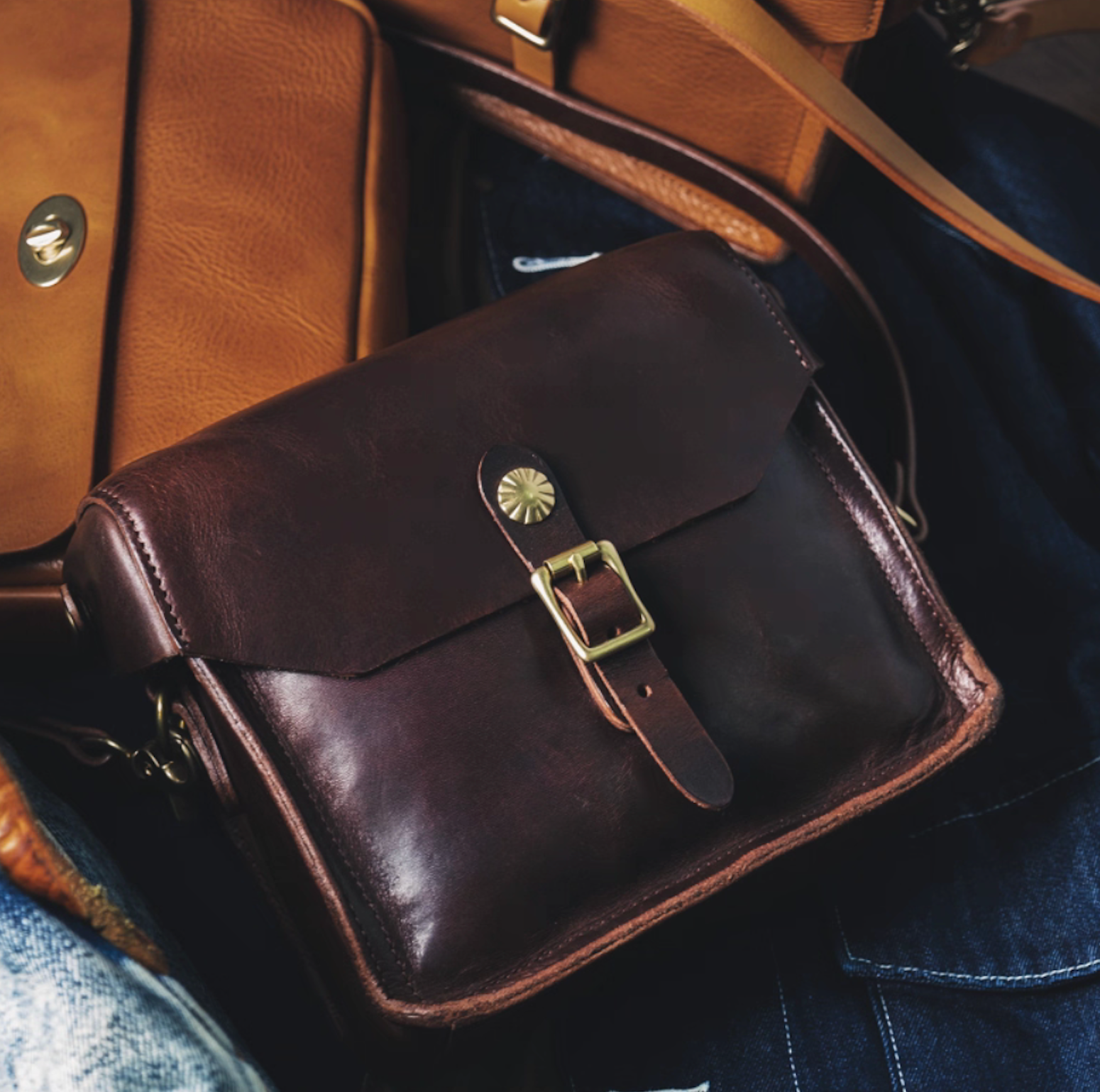 Dark brown Italian leather artisan military satchel with brass buckle flat lay
