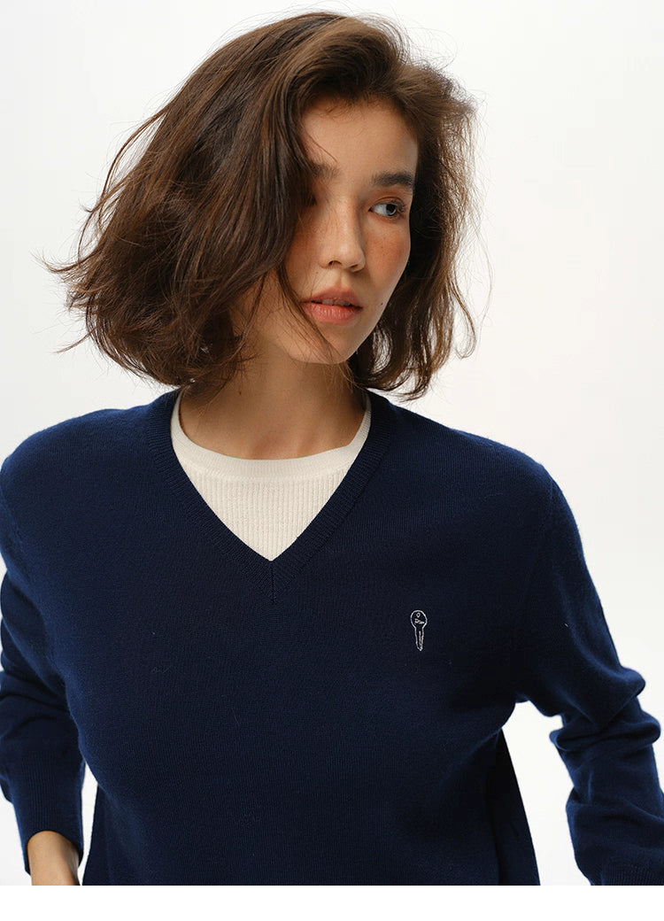 Close-up of Navy Blue merino wool V-neck sweater highlighting neckline and embroidery