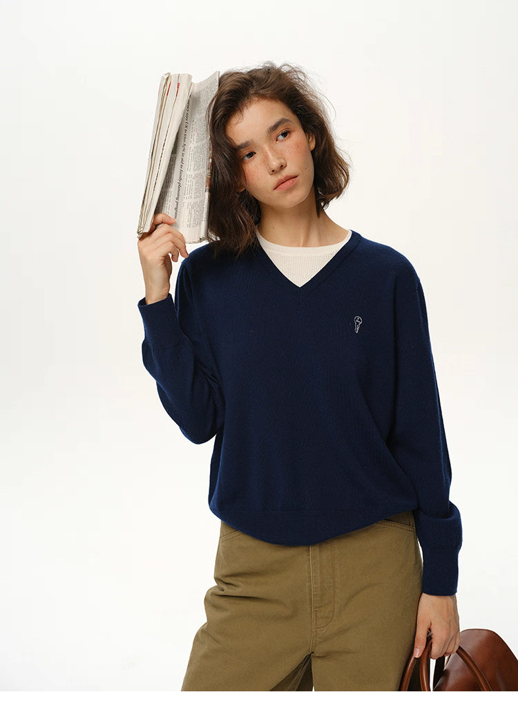 Navy Blue merino wool V-neck sweater styled with newspaper and khaki pants