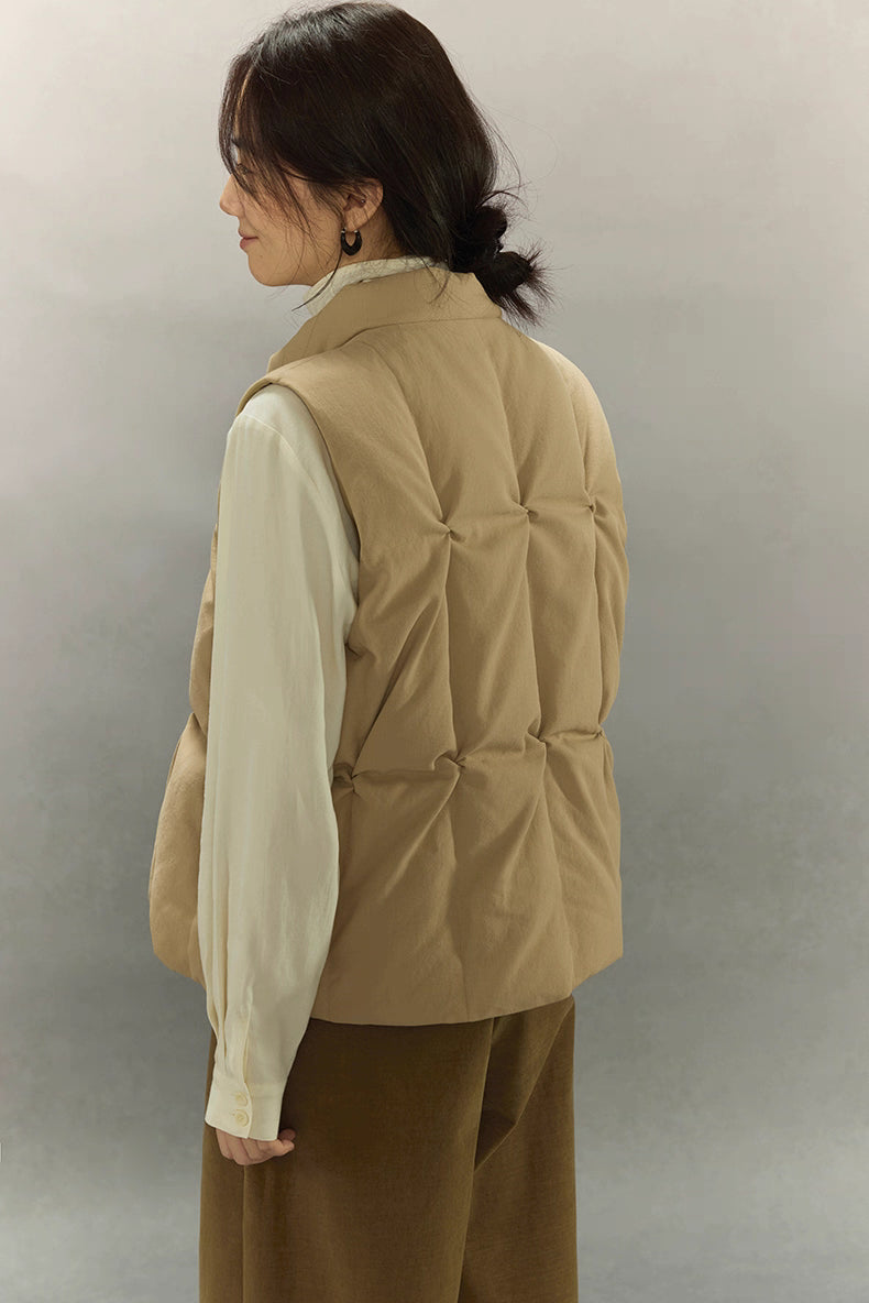 back view showing sculpted pinched quilting on beige down vest