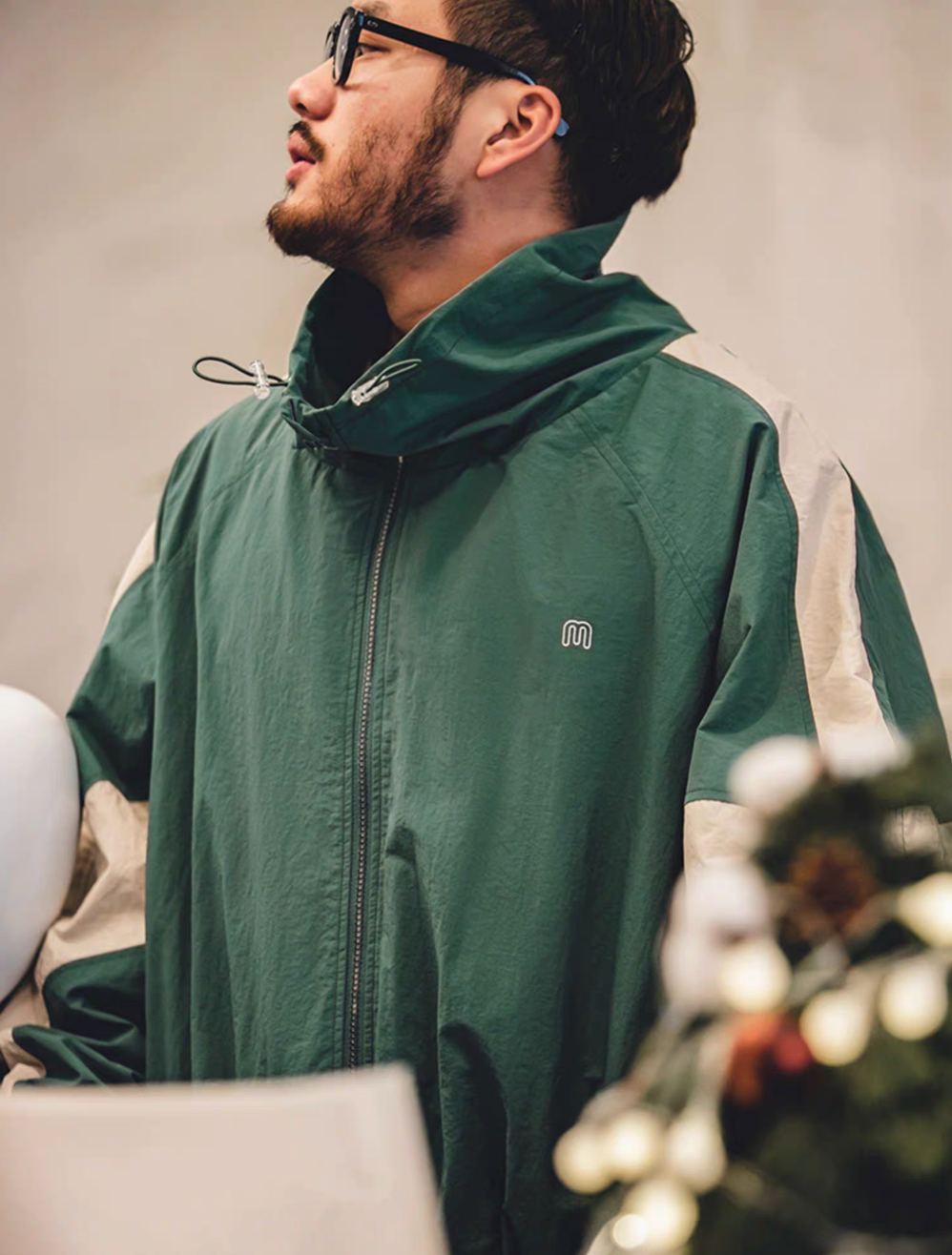 Side profile of Arden Green Dynamic Layering Jacket worn by model showing structured collar and color block sleeve detail