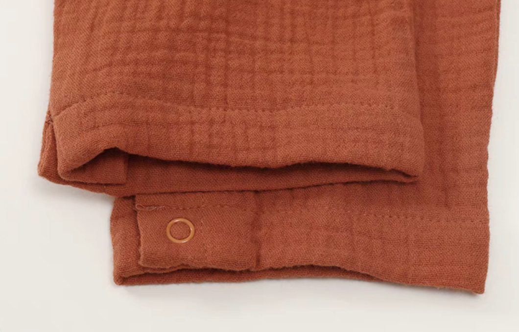 Close-up of orange red romper sleeve cuff and stitching detail