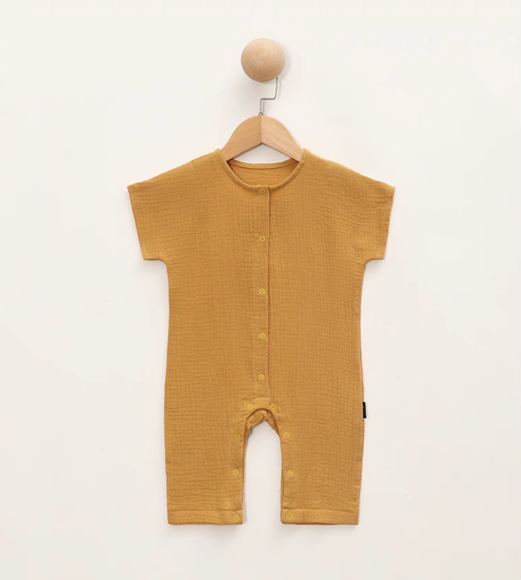 Yellow short sleeve baby romper hanging on wooden hanger front view