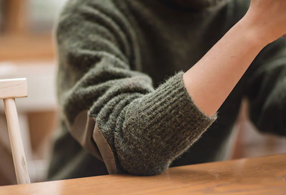 Close up of Elbow Patch Turtleneck Sweater in olive green showing ribbed cuff texture and durable knit construction