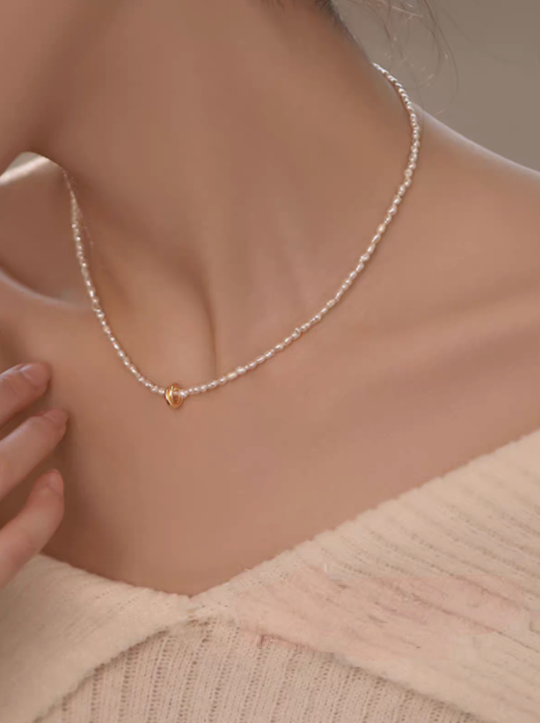 Golden Knot Freshwater Pearl Necklace worn on model showing delicate pearl strand and gold knot centerpiece