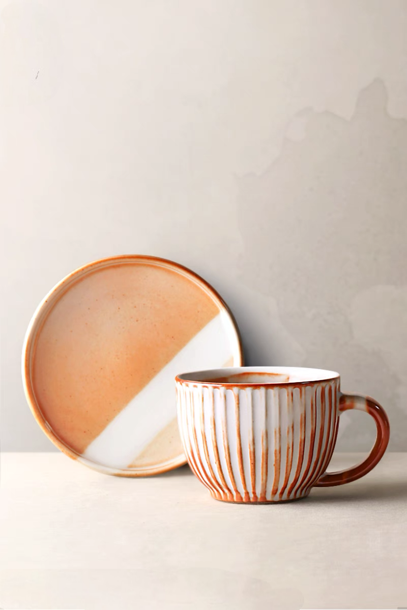 Style 2 handcrafted vintage ceramic mug in off-white and orange placed on table with coffee creating warm lifestyle scene