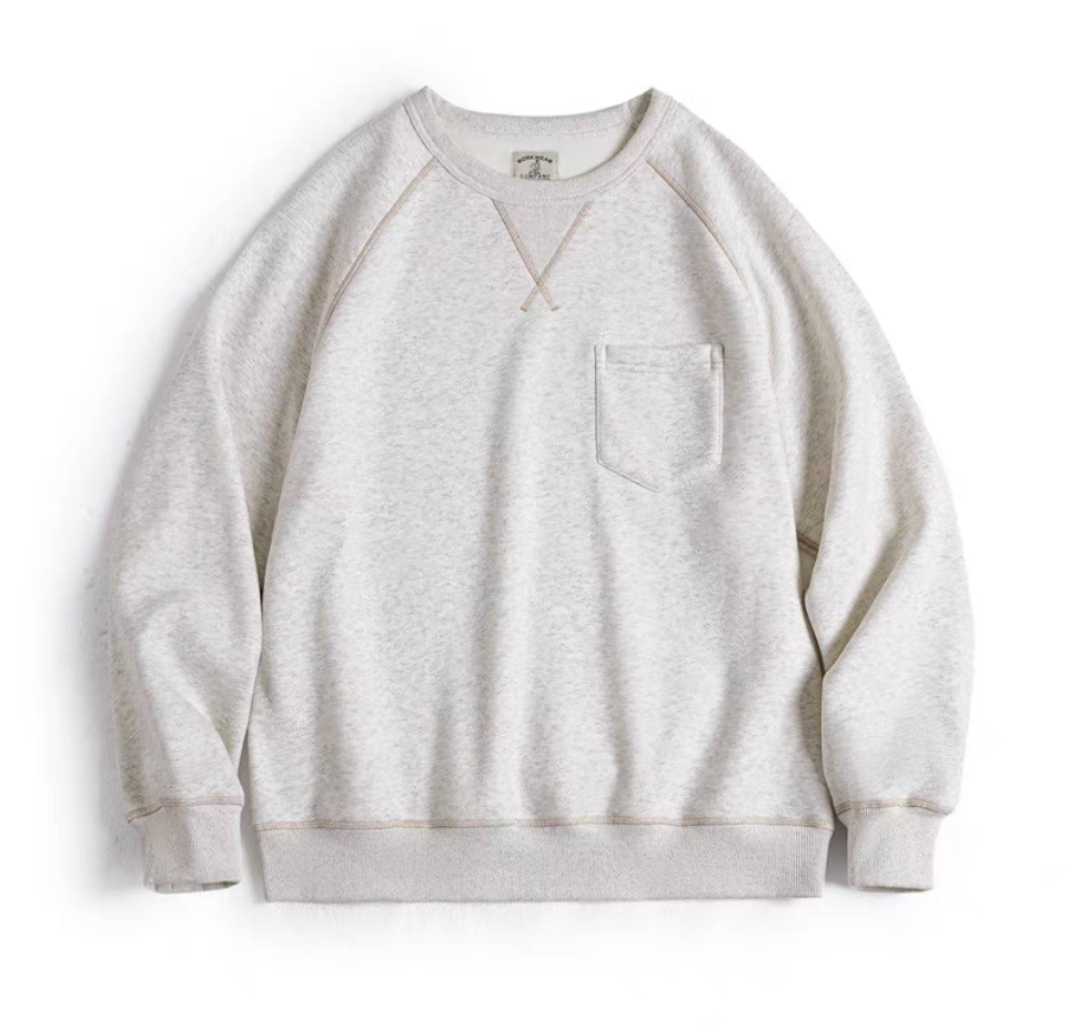 Flat lay of heather light gray heavyweight fleece crewneck sweatshirt with chest pocket.