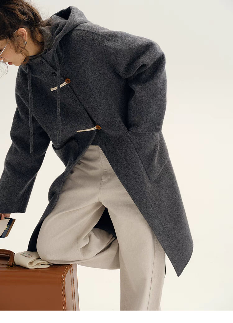 Side view of Highland Wool Toggle Coat in dark gray in dynamic pose highlighting toggle closure, relaxed fit, and structured wool fabric