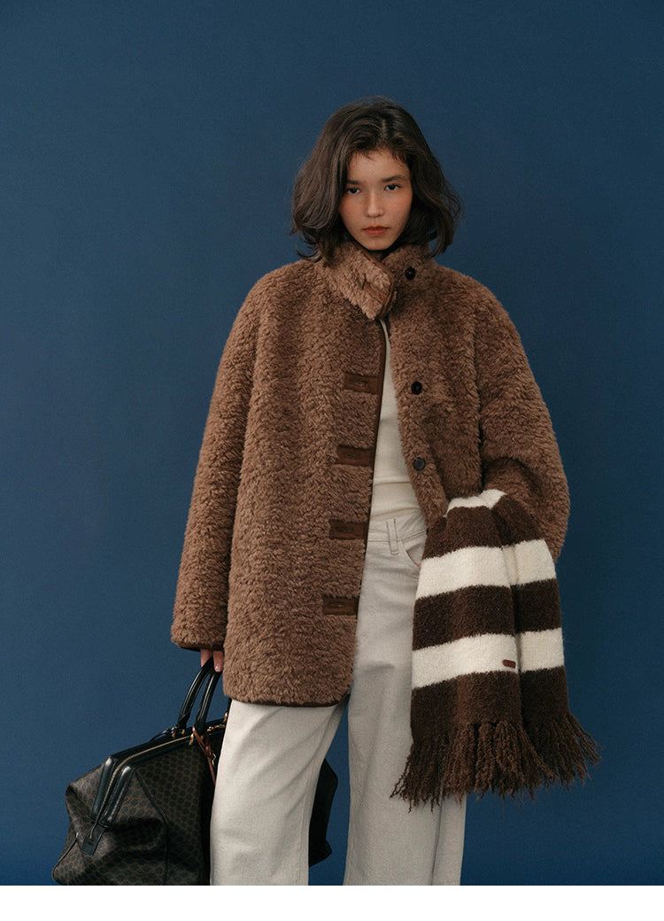 Model wearing chocolate-brown teddy wool-blend coat, front view against navy backdrop.