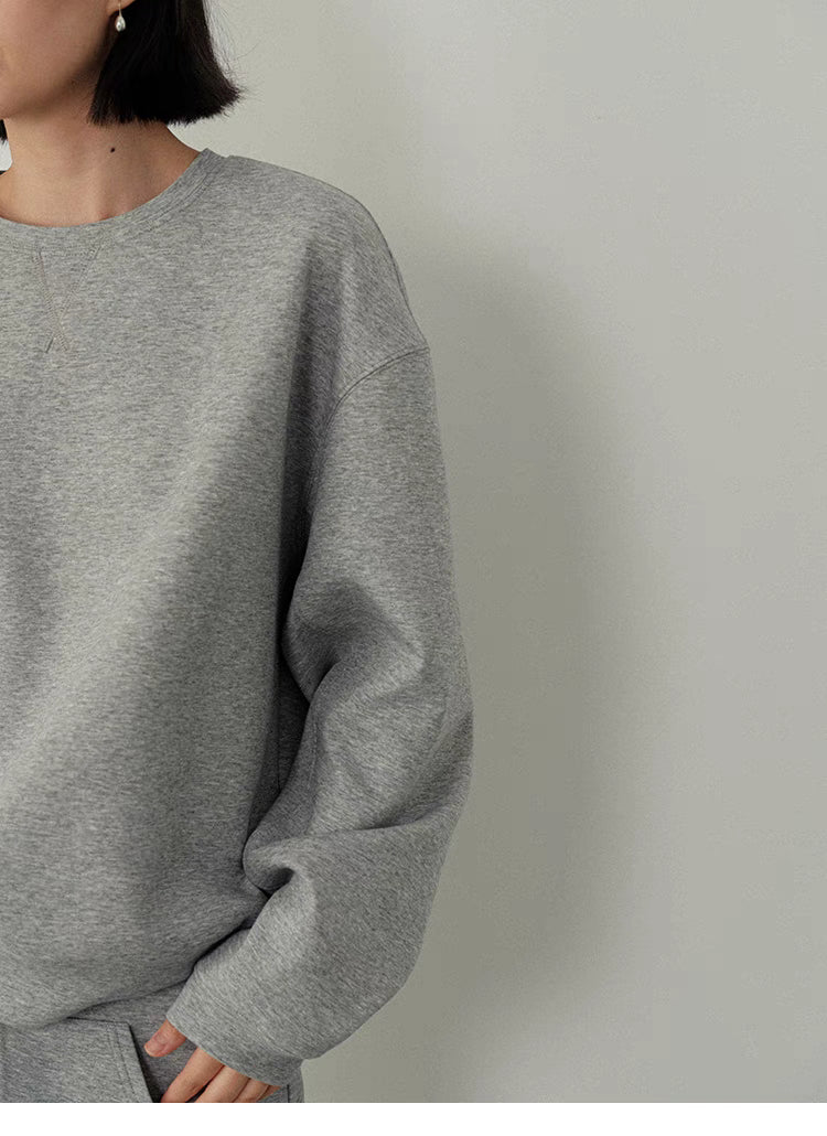 Close-up detail of women’s light gray oversized sweatshirt fabric & design