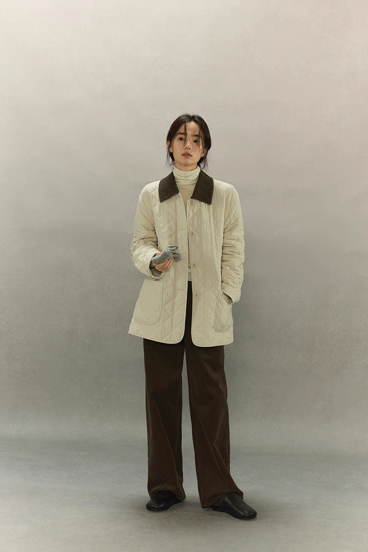 full-body front view of cream quilted barn coat styled with brown pants