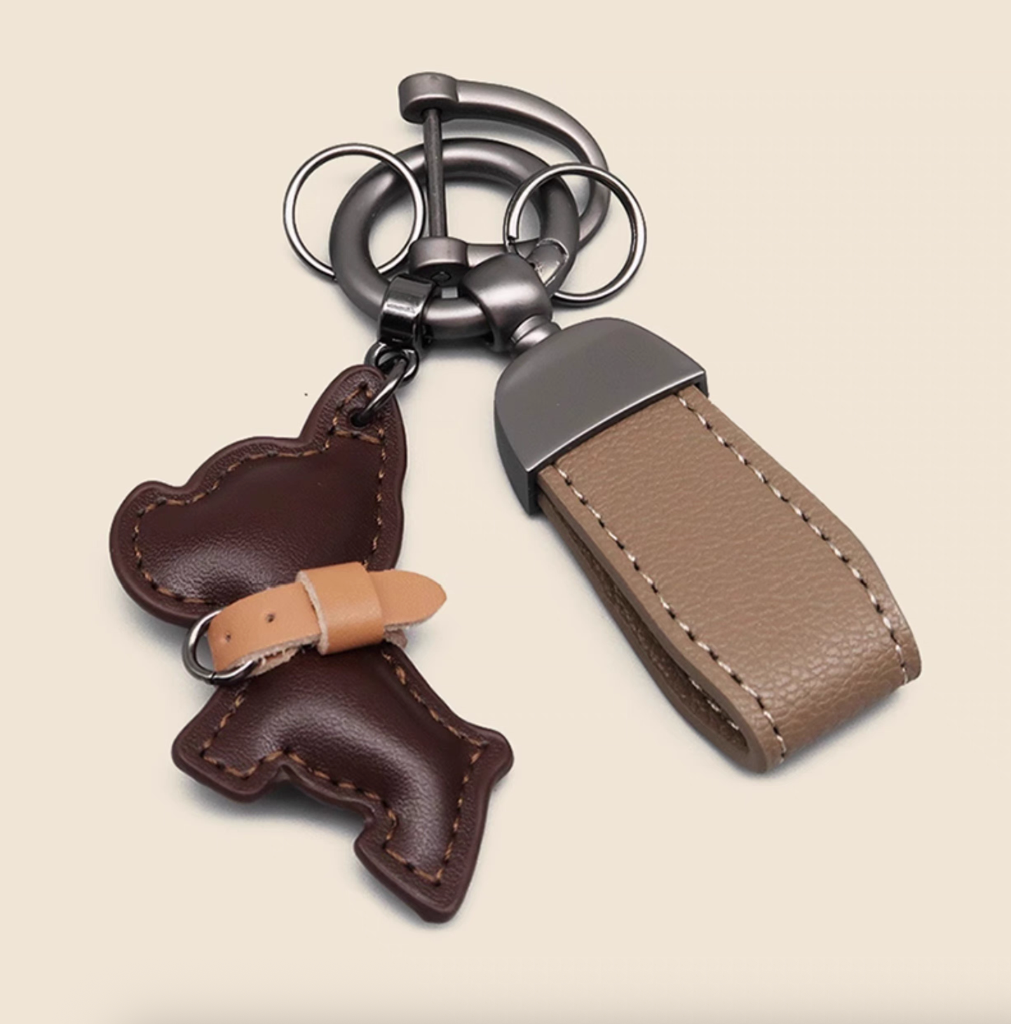 Dark brown PU leather puppy keychain with stitched detail and tan strap.