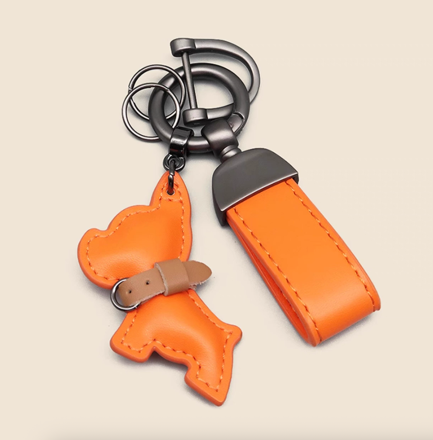 Orange PU leather puppy keychain with wrist strap and sturdy gunmetal hardware.