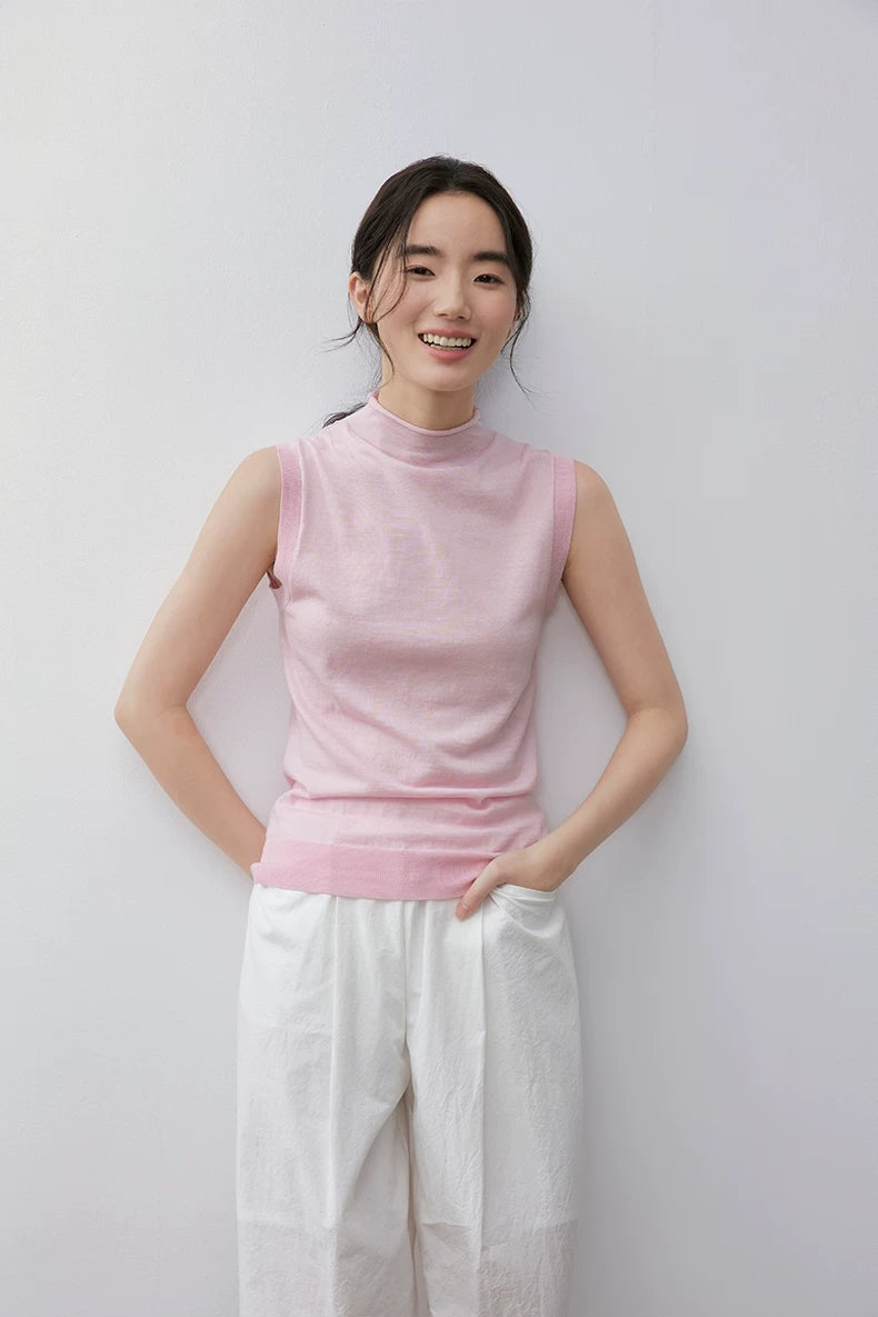 Smiling model in Light Pink slim-fit sleeveless mock neck knit top, front view