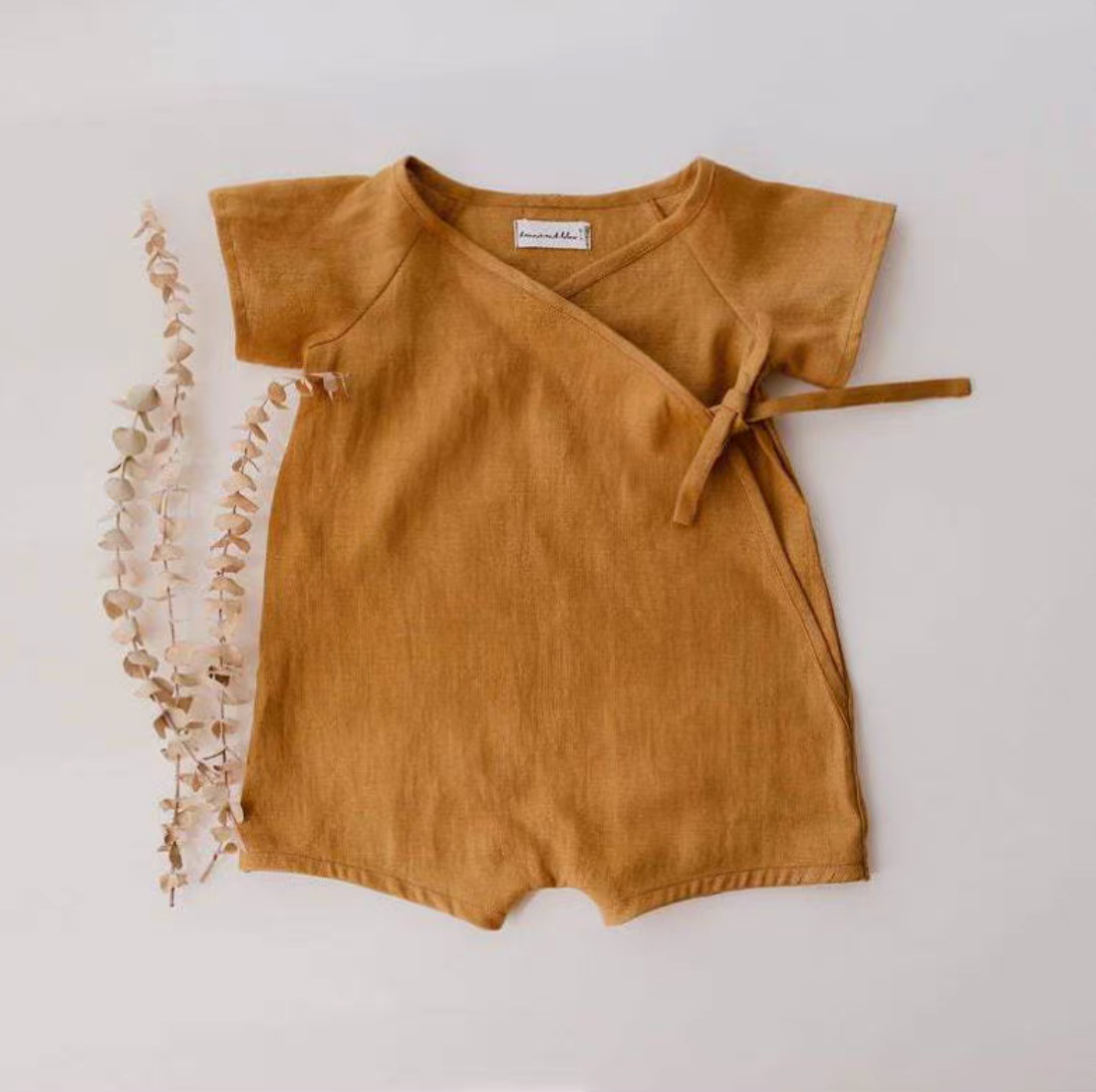 Mustard cotton muslin baby romper with wrap tie detail front view