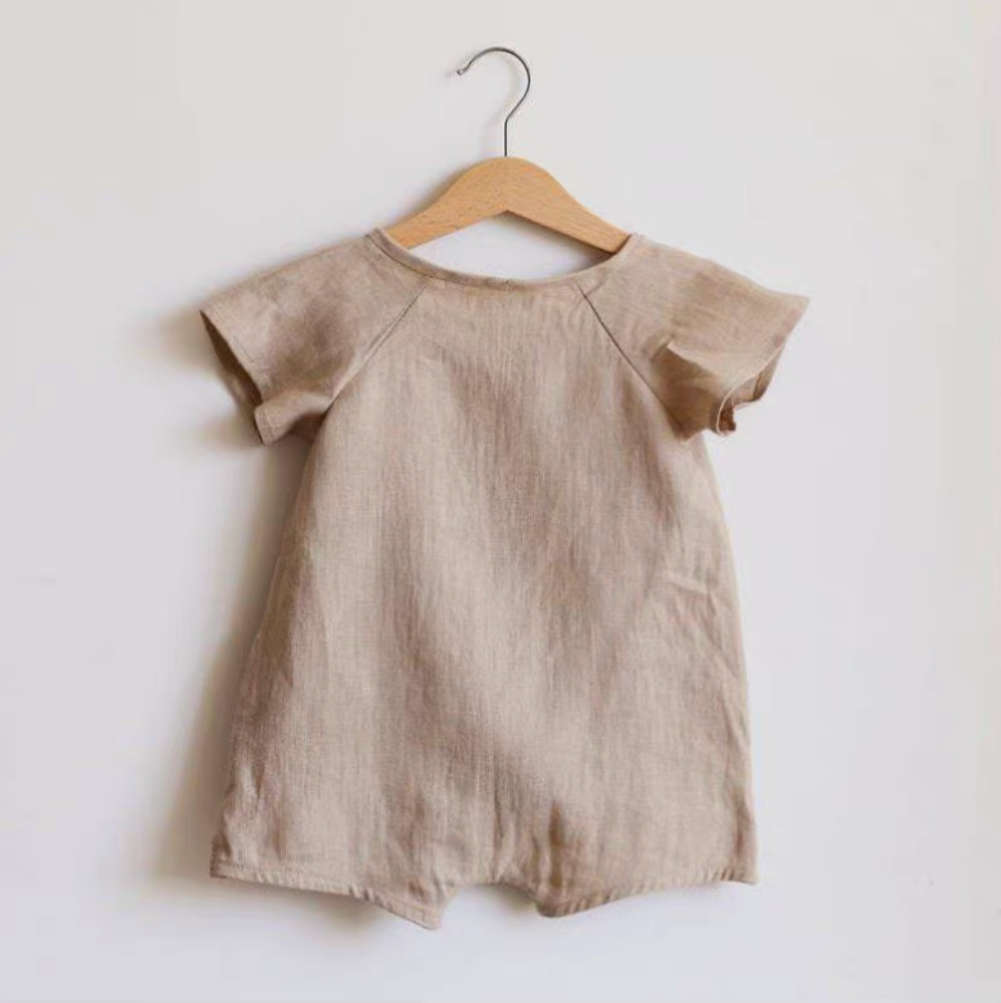 Back view of oatmeal lightweight cotton muslin baby romper on hanger