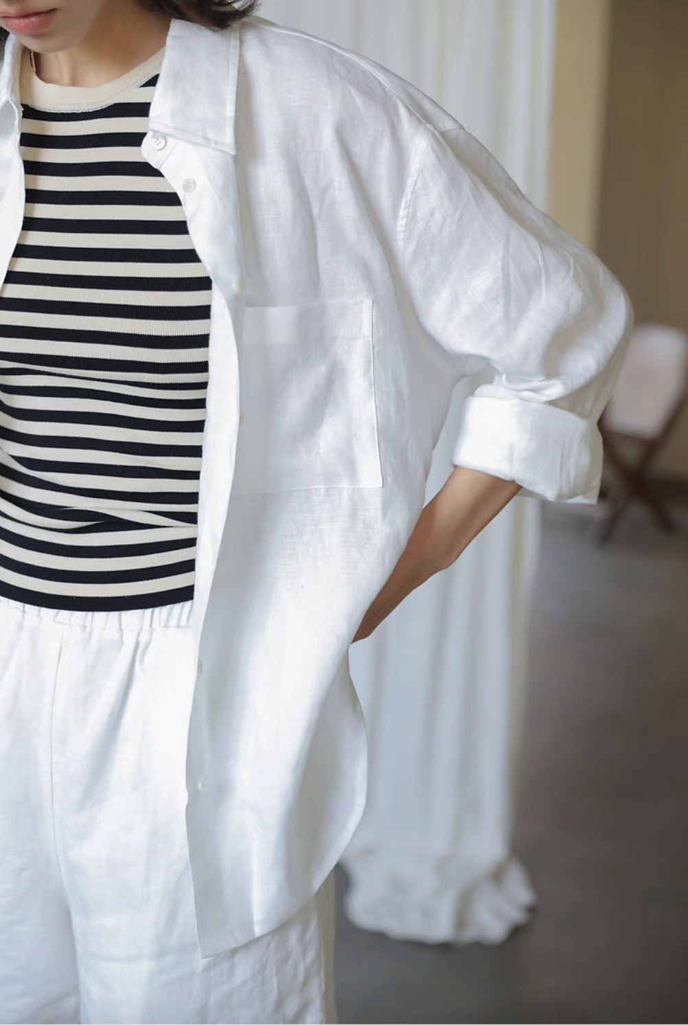 White linen collared shirt close-up detail with striped inner top showing breathable fabric texture