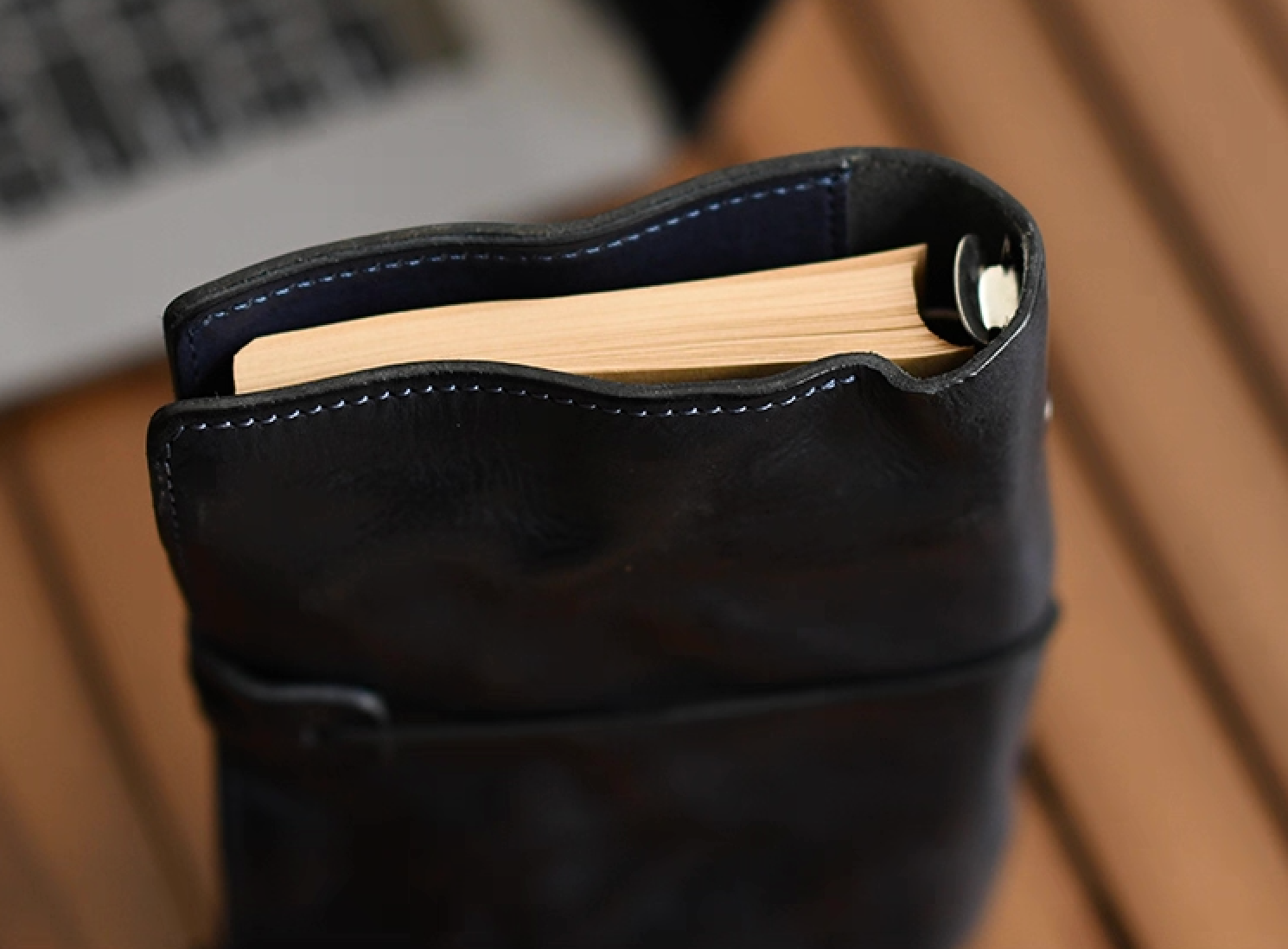 Top view of navy leather journal standing upright, showing inserted notebook pages.