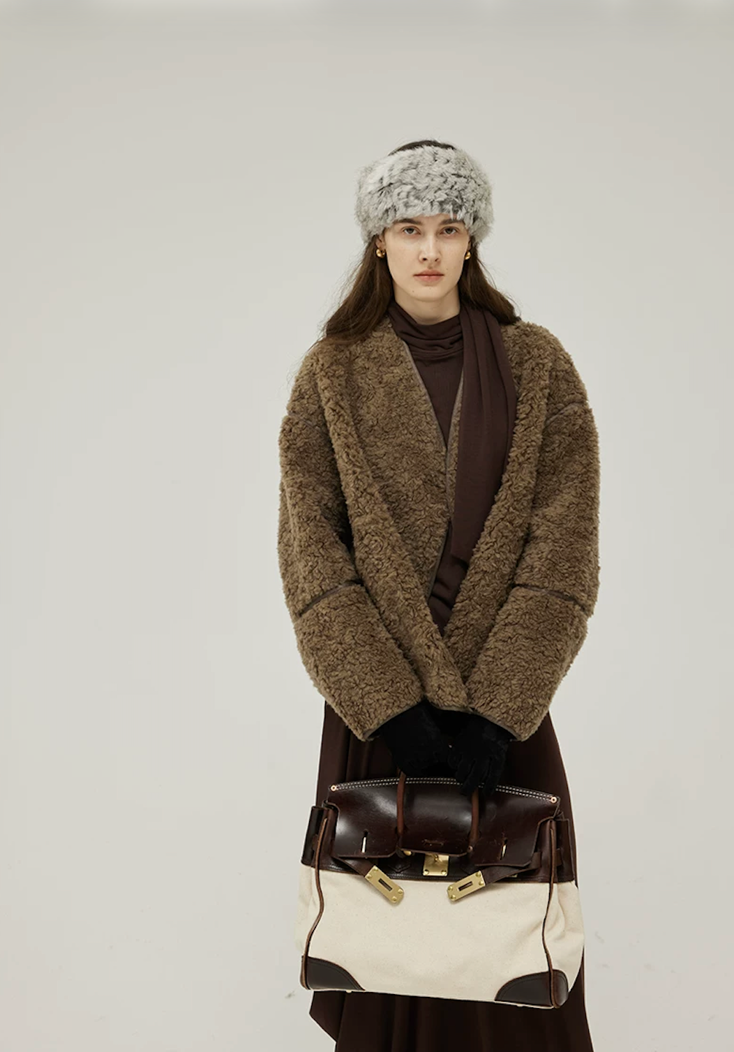 Olive Brown curly wool teddy jacket worn open, showing the deep V-neckline and sheepskin-trimmed cuffs