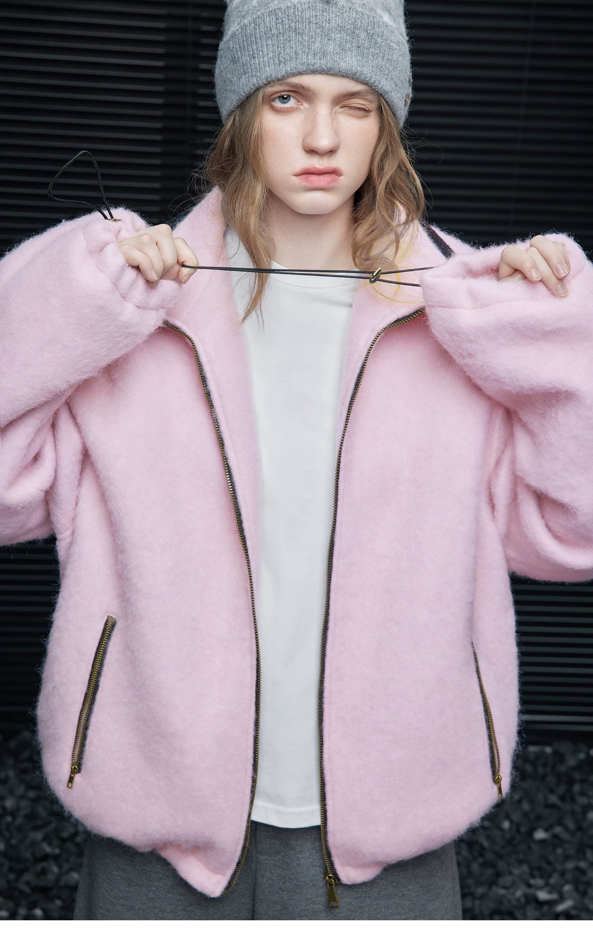 Pink oversized wool-blend jacket worn unzipped, showing the drawcord toggles at the cuffs