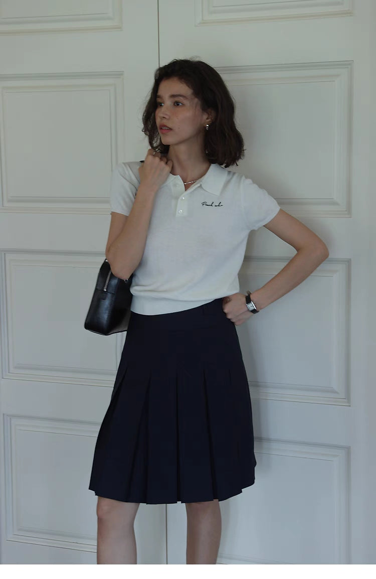 Pleated Chic Skirt navy blue high waist front view styled with white top, showcasing structured pleats and flattering silhouette