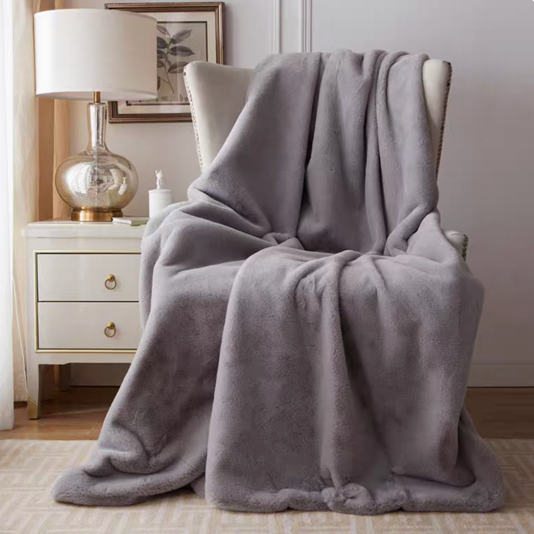 Light gray plush faux fur throw blanket draped over chair in modern elegant home decor