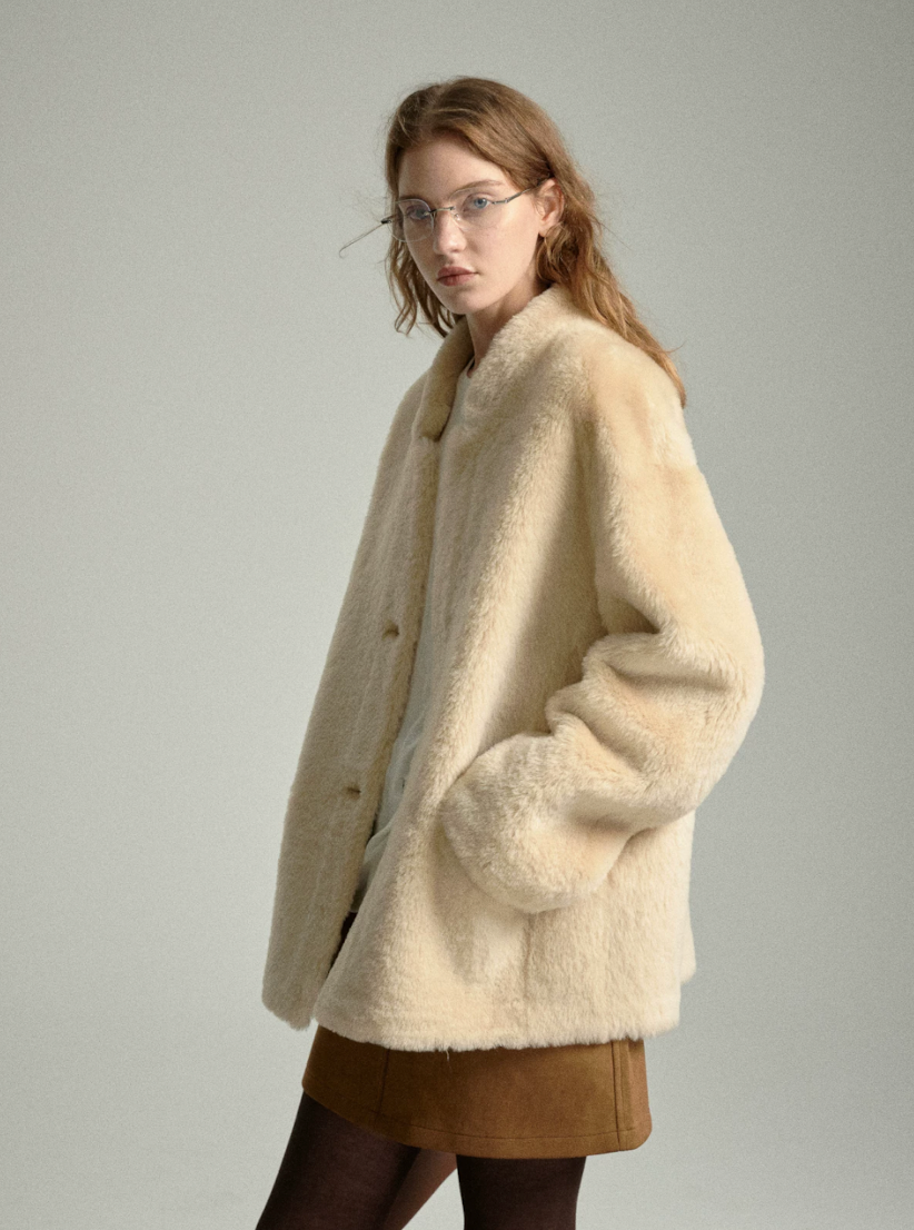 Side view of oat shearling jacket with hands in front pockets