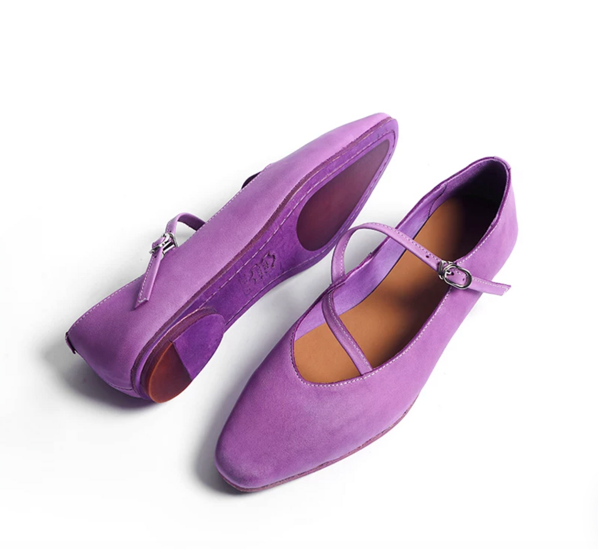 Purple ballet flats showing the leather outsole with rubber grip patches and the crossed strap
