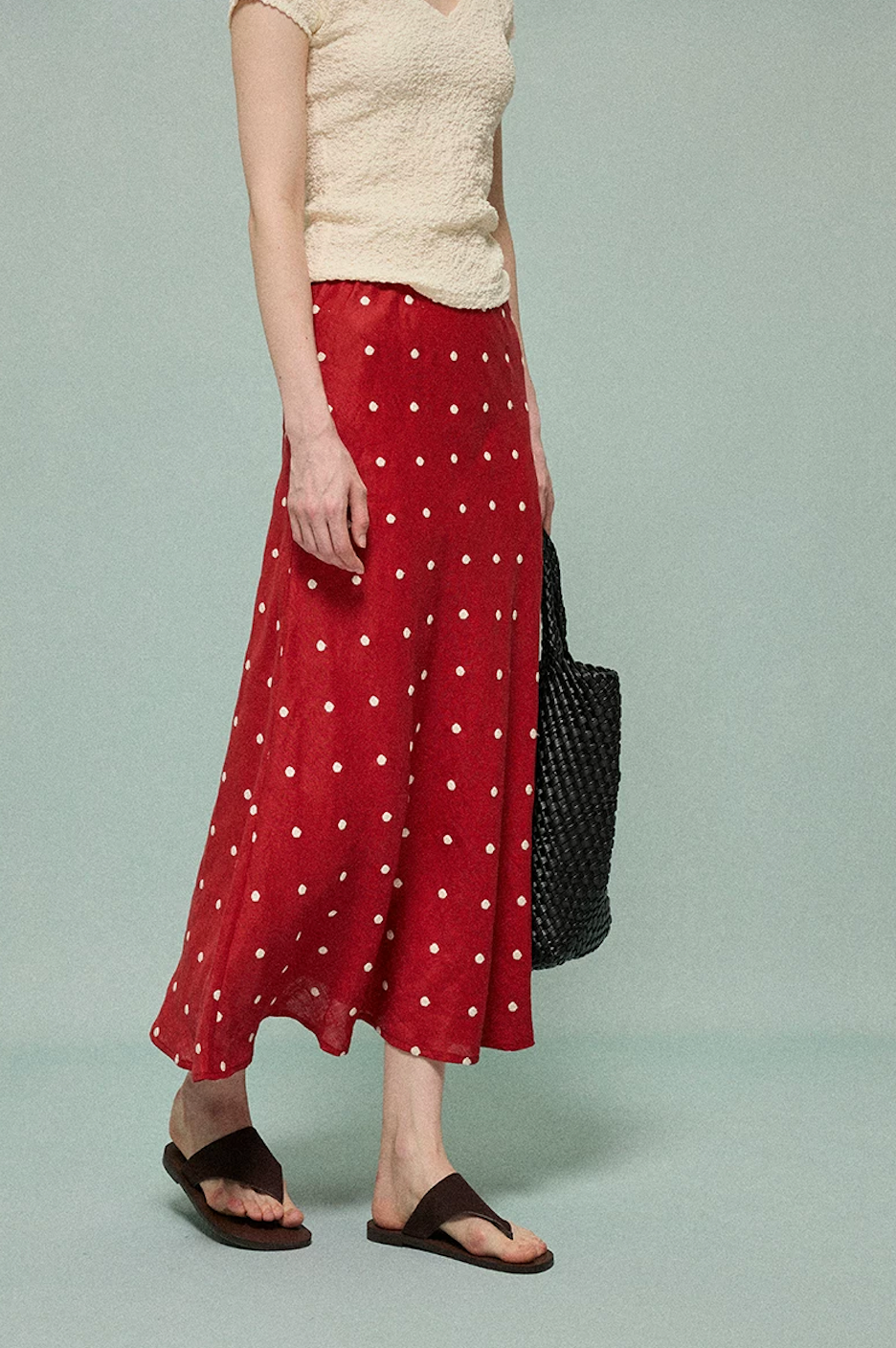 Red linen midi skirt with cream embroidered polka dots, side angle view