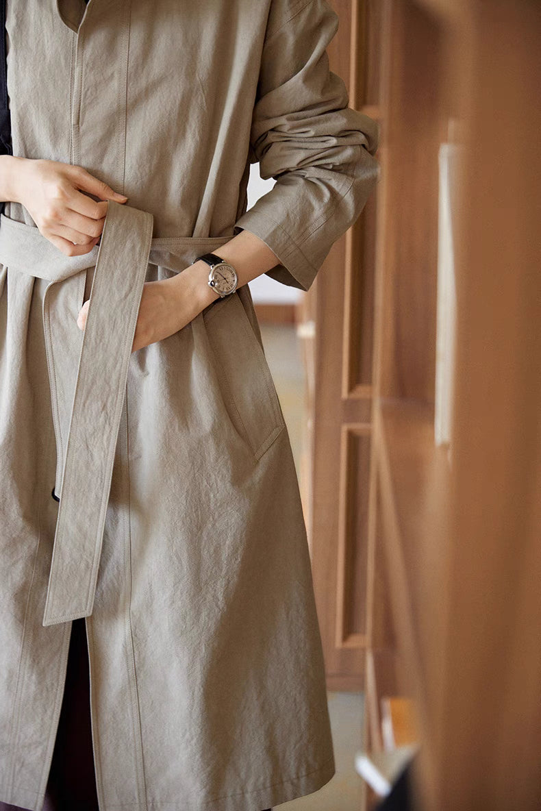 Close-up detail of the gray Relaxed Cotton-Linen Trench showing the detachable belt, side-seam pocket, and softly wrinkled cotton-linen fabric