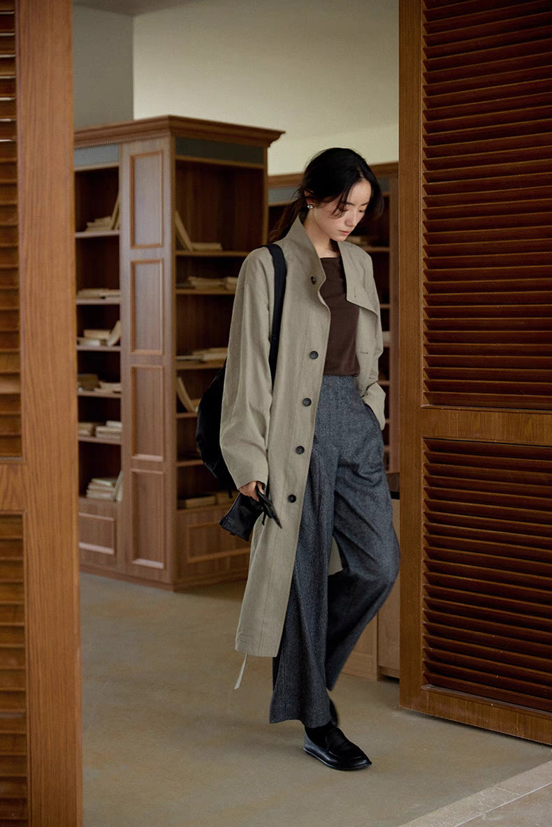 Woman wearing Relaxed Cotton-Linen Trench in gray walking indoors, featuring a detachable belt, relaxed fit, and breathable cotton-linen fabric