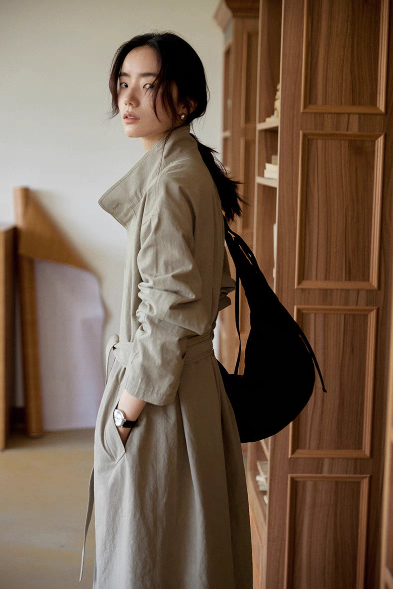 Side back view of woman wearing the gray Relaxed Cotton-Linen Trench with a shoulder bag, featuring a belted waist, clean drape, and effortless layered style